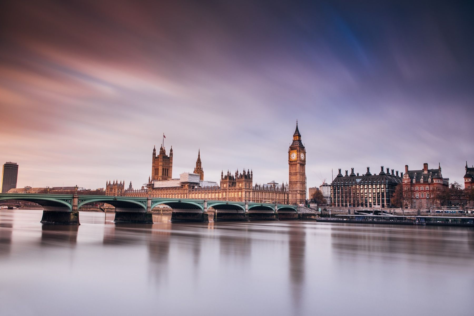 The Houses of Parliament and Westminster Bridge across the Thames under a streaked evening sky