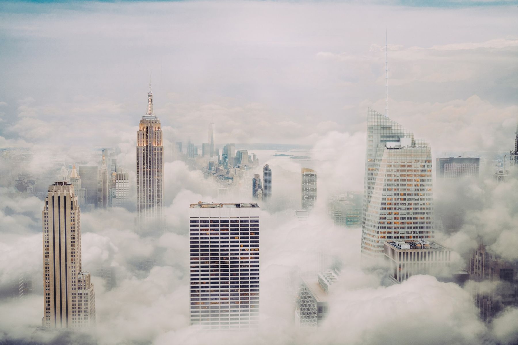 Manhattan skyscrapers rising through low cloud, seen from above